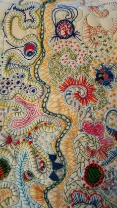 an embroidered piece with many different colors and patterns on the fabric, including paisleys