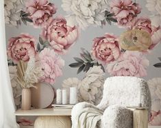 a floral wallpaper with pink flowers and leaves on the walls is next to a white chair