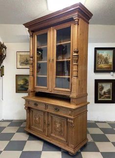 a large wooden cabinet sitting on top of a checkered floor