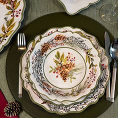 a place setting with pine cones and berries