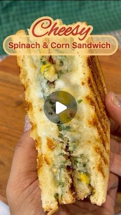 a hand holding a sandwich with spinach and corn on it