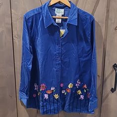 Soft Royal Blue Button Up Velvet Top, With Embroidered Flowers Around Hem On Front, Two On Back. Includes 3 Button Covers. Blue Embroidered Collared Blouse, Embroidered Collared Blue Tops, Blue Embroidered Collared Shirt, Blue Collared Shirt With Floral Embroidery, Blue Cotton Shirt With Floral Embroidery, Blue Button-up Shirt With Floral Embroidery, Blue Embroidered Button-up Blouse, Blue Floral Embroidered Button-up Blouse, Fitted Blue Shirt With Floral Embroidery