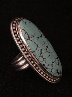 "Ring ~ Artist: Teresa Bradford-Cole Large Oval Turquoise Heavy Gage Sterling Silver Size: 10 1/2 Length: 2\" Width: 1\" Solid Silver Back Many tribes considered turquoise to be a stone of the sky, and wearing items of turquoise jewelry provided protection, good health and long life. The name turquoise is apparently related to the fact that is was brought to Europe from the Eastern Mediterranean by Levantine traders, more commonly known as Turks. Its been used as a valuable ornament for ages and Statement Piece Jewelry, Antique Silver Rings, Metal Smithing, Pacific Grove, Beaded Handbag, Big Rings, Skull Necklace, Turquoise Rings, White Buffalo