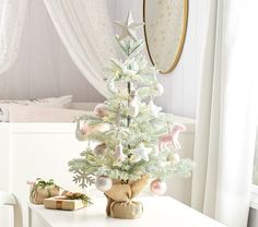 a small white christmas tree sitting on top of a table