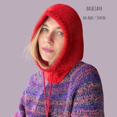 a woman wearing a red knitted hoodie over her face and looking at the camera