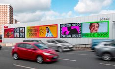 cars driving down the road in front of billboards