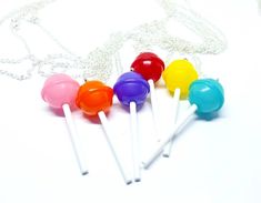 several different colored lollipops on a white surface with a chain around them