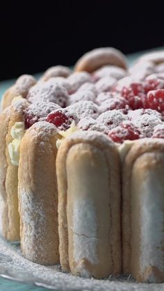 a cake with powdered sugar and raspberries on top