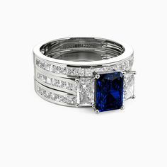 a blue and white diamond ring set with two princess cut diamonds on each side, in 18k white gold