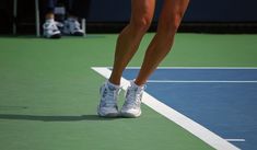 a woman standing on top of a tennis court holding a racquet in her hand