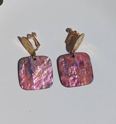 A gorgeous pair of dangle pink statement clip-on earrings that will differently had glamorous to your outfit. This earring is very lightweight and will glow in the sun a must for non pierced ears. They are a perfect clip earrings for you or can be gifted to a friend,mum, sister, and girlfriend. Perfect clip on earrings for women, get you a pair you wouldn't be disappointed. Fast Shipping 🙂 Materials : -Clip On [ Screw] -Metal Parts -Acrylic -Resin -Wood -Brass Dimensions: -Length 5cm -Width 3cm Pink Clip-on Earrings As Gift, Pink Dangle Clip-on Jewelry, Pink Clip-on Dangle Jewelry, Elegant Pink Dangle Clip-on Earrings, Pink Clip-on Drop Earrings, Elegant Handmade Pink Clip-on Earrings, Rose Gold Clip-on Earrings, Non Pierced Earrings, Women Earrings