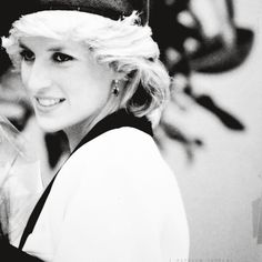 a black and white photo of a woman wearing a hat