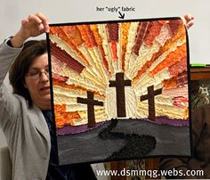 a woman holding up a quilt with the image of jesus and three crosses on it