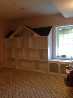 an empty room with bookshelves and a window