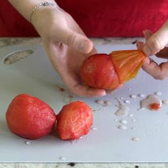 a person is peeling an orange on a cutting board