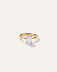 a gold ring with an emerald cut stone