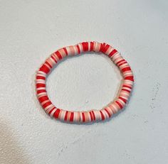 a red and white striped bracelet on a table