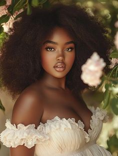 a woman with an afro is posing in front of some pink flowers and greenery