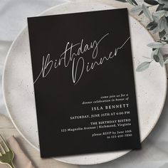 a black and white birthday dinner party card on a plate with silverware next to it