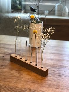 vases filled with flowers sitting on top of a wooden table