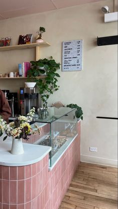 a woman standing behind a counter with flowers on it