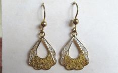 Hi there and welcome to 'In the magpie's nest' For sale - A pair of vintage 60's sterling silver gold plated filigree drop dangle earrings 925 Earring type - Drop/dangle Shape - Fan Measurement - 4cm's (length inc hook) 1.7cm's (width) Backs - Hooks Metal - Sterling silver (gold plated) - 925 - 2.52g Decoration - Filigree Era - 1960's -------------------------------------------------------------------------------------------------- Condition - Good condition - (see pics) Your earrings will come packaged in a gift box -------------------------------------------------------------------------------------------------- Important info - All the items I sell are either vintage or pre-loved and as such will show signs of wear consistent with their age. Items may look larger in photos so please che Antique Filigree Drop Earrings, Vintage Earrings With Intricate Design, Yellow Gold Filigree Metal Jewelry, Yellow Gold Filigree Jewelry, Vintage Pierced Metal Jewelry, Filigree Dangle Jewelry For Anniversary, Vintage Handmade Earrings For Anniversary, Vintage Sterling Silver Filigree Earrings, Silver Filigree Brass Jewelry