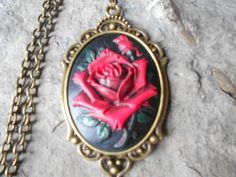 For sale are red rose with black through and green leaves and stem, cameo pendant necklaces!!!!  Gorgeous unique colors, each individually hand painted, each an original!!! 2" long!!!  They are offered at a reasonable price, make perfect gifts, and are wonderful quality!!!!  Timeless and Classic look!!!  The cameo is set in a bronze setting, and the chain is 24" adjustable rolo link chain, with a lobster claw clasp!!!!  I make several varieties, colors, styles and matching sets!!!!  I will be gl Gothic Rose-colored Jewelry For Gifts, Red Cameo Necklace For Gift, Gothic Rose Colored Jewelry For Gift, Gothic Rose Jewelry For Gift, Rose-colored Gothic Jewelry For Gift, Gothic Cameo Necklaces For Gifts, Gothic Cameo Necklaces As Gift, Gothic Cameo Necklace As Gift, Gothic Cameo Necklace For Gift