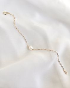 Make a classy statement with this delicate pearl bracelet. Simple and sophisticated, this everyday bracelet features a single oval pearl with our classic thin cable chain. Adds a subtle elegance to any outfit. Available in 14k Gold Filled or Sterling Silver. Details: Everyday Pearl Bracelet Single Oval Cream Freshwater Pearl (Size Approximately 6mm - 7mm In Length; 5mm to 6mm In Width) Thin Delicate 2mm Cable Chain Spring Ring Clasp Closure Choose Your Length In Inches ★ JEWELRY CARE ★To extend the lifecycle of your jewelry and minimize tarnish, please keep away from household cleaners, hair and personal body care products. Please remove before bathing, exercising, swimming, and at night before sleeping. Please store in a clean, dry place alone or with similar items. ★ PRODUCTION + SHIPPIN Pearl Bracelet Gold, Everyday Bracelet, Bracelet Simple, Subtle Elegance, Pearl Size, Pearl Bracelet, Cable Chain, Spring Rings, Delicate Bracelet