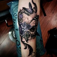 a woman's arm with butterflies and flowers on it