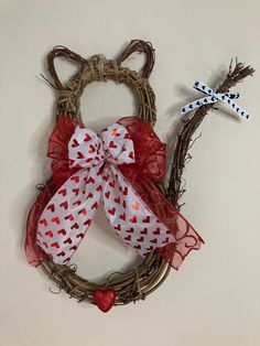 a wreath with two bows and hearts on it