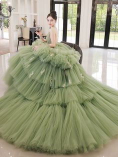 Step into a world of elegance and sophistication with our Sage Green Tiered Tulle Gown. This exquisite ball gown features a stunning tiered tulle skirt that creates a dramatic and voluminous silhouette, perfect for making a grand entrance. The corset back adds a touch of timeless charm while ensuring a perfect fit. The gown's sage green hue exudes a sense of tranquility and grace, making it an ideal choice for any formal occasion. Delicate embellishments and intricate detailing enhance the gown's luxurious appeal, while the off-shoulder neckline adds a romantic touch. Designed with comfort and style in mind, this gown allows you to move with ease and confidence. Whether you're attending a wedding, gala, or any special event, this Sage Green Tiered Tulle Gown promises to make you the center Prom Dress Green, Simple Satin Wedding Dress, Tulle Long Prom Dress, Nontraditional Wedding Dress, Antoinette Dress, Sweet 16 Dress, Tiered Tulle Skirt, Fairy Wedding Dress, Gothic Wedding Dress