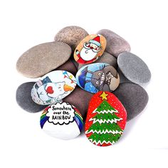 some rocks with different designs on them and a christmas tree painted on the rocks next to it