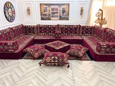 a living room filled with lots of red couches and rugs on the floor