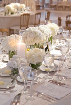 the table is set with white flowers and candles