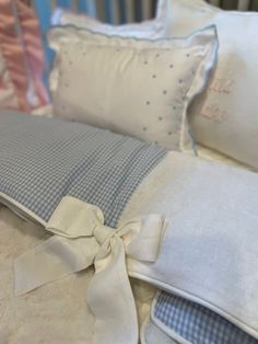 a baby crib with blue and white bedding and pillows on top of it