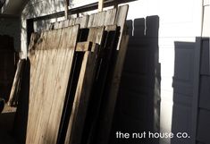 an old wooden door is leaning against the side of a house with it's shutters open