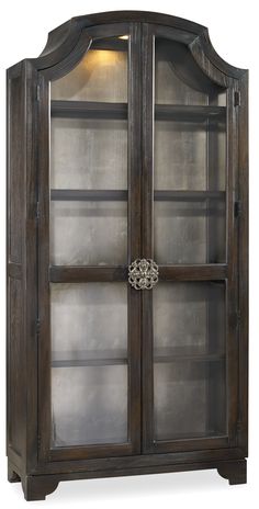 an old wooden cabinet with glass doors and metal trimmings on the bottom shelf