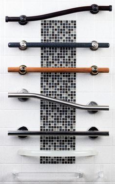 a wall mounted rack with several different types of handles on it's sides in a bathroom