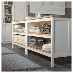 a kitchen with white cupboards and shelves filled with bowls, pans and utensils