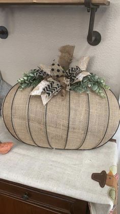 a decorative pumpkin sitting on top of a table next to a wall mounted coat rack