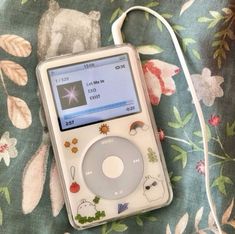 an ipod sitting on top of a floral blanket