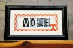 the university of tennessee word art is displayed in a black frame on top of a wooden shelf