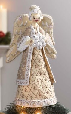 an angel ornament on top of a christmas tree