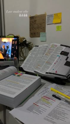 an open book sitting on top of a desk next to a computer monitor and keyboard