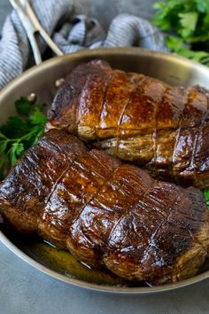 two steaks in a pan with parsley on the side, ready to be eaten