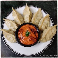 some dumplings are on a plate with sauce