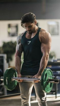 a man is standing in front of a barbell