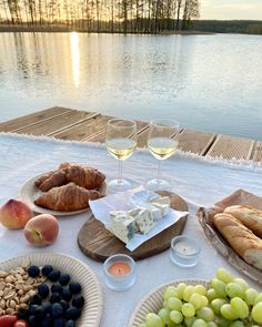 a table topped with plates of food and glasses of wine