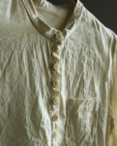 Linen shirt LONDON This shirt is made of 100% natural high-quality lightweight linen, cream color. It's not sheer, but fabric is made of finest linen fibres and some parts of your silhouette can be visible in a bright light. It has a halfway down button closure, tailed hem, band collar, wide cuffs with two buttons on each, small lovely pocket attached with invisible stitch. Cuffs, collar line and pocket are hand stitched with natural linen thread. Buttons are made of palm tree or coconut dependi Mens Linen Outfits, Thread Buttons, Victorian Shirt, Grandfather Shirts, Invisible Stitch, Linen Thread, Collarless Shirt, White Linen Shirt, Stylish Men Casual