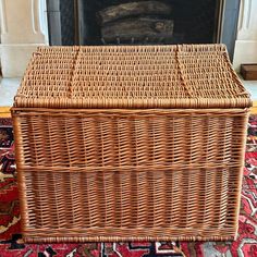 a wicker basket sitting on top of a rug in front of a fire place